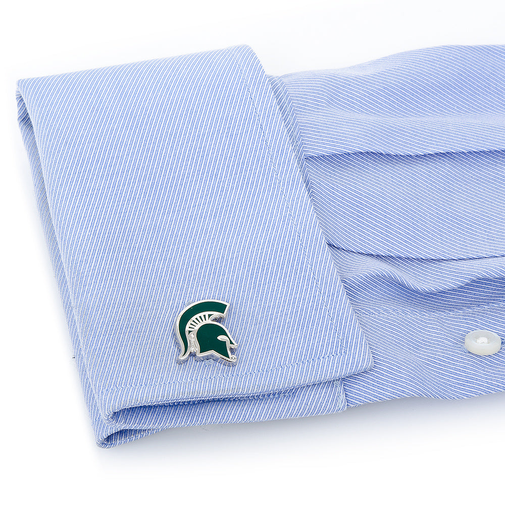 Folded light blue dress shirt with a green and white logo on a white background