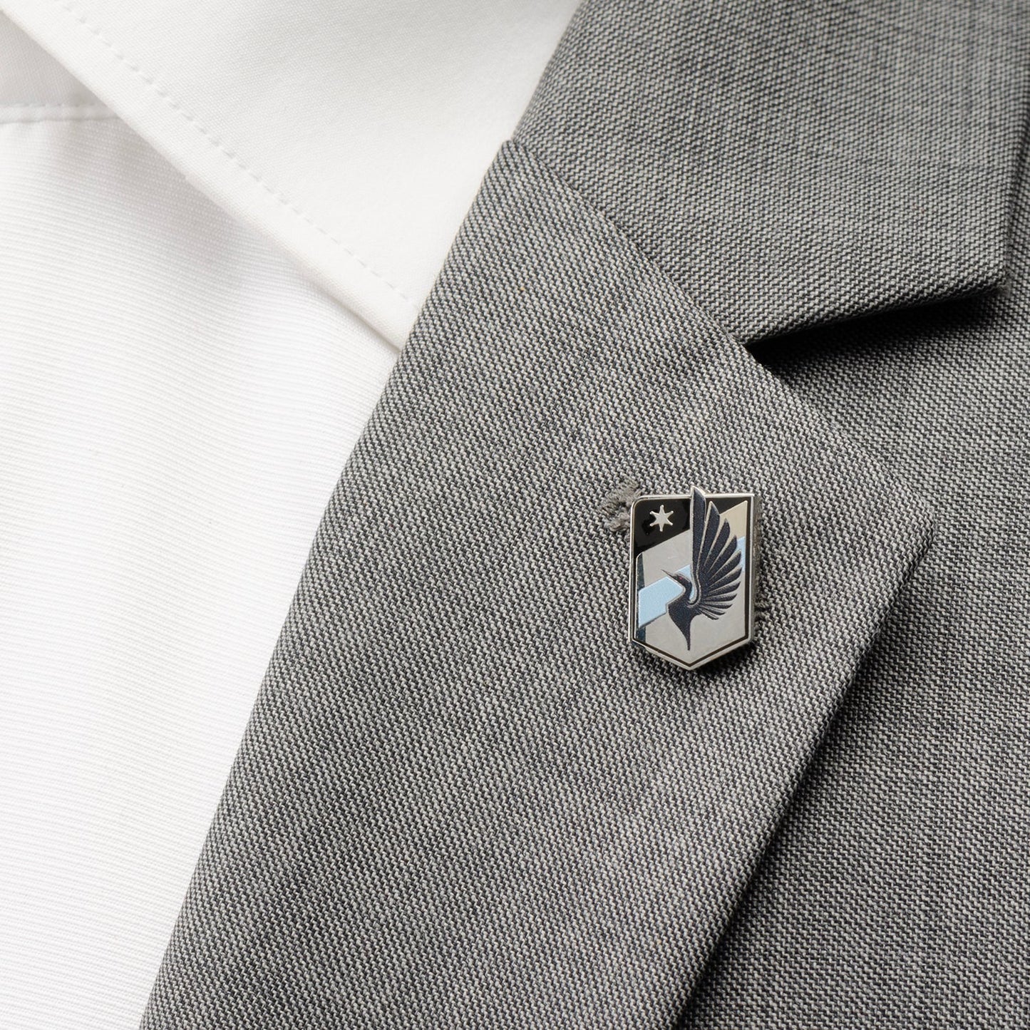 Pin on a gray suit jacket with a white shirt background MLS Minnesota United Lapel Pin