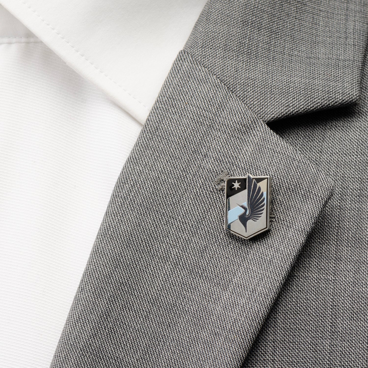 Pin on a gray suit jacket with a white shirt background MLS Minnesota United Lapel Pin