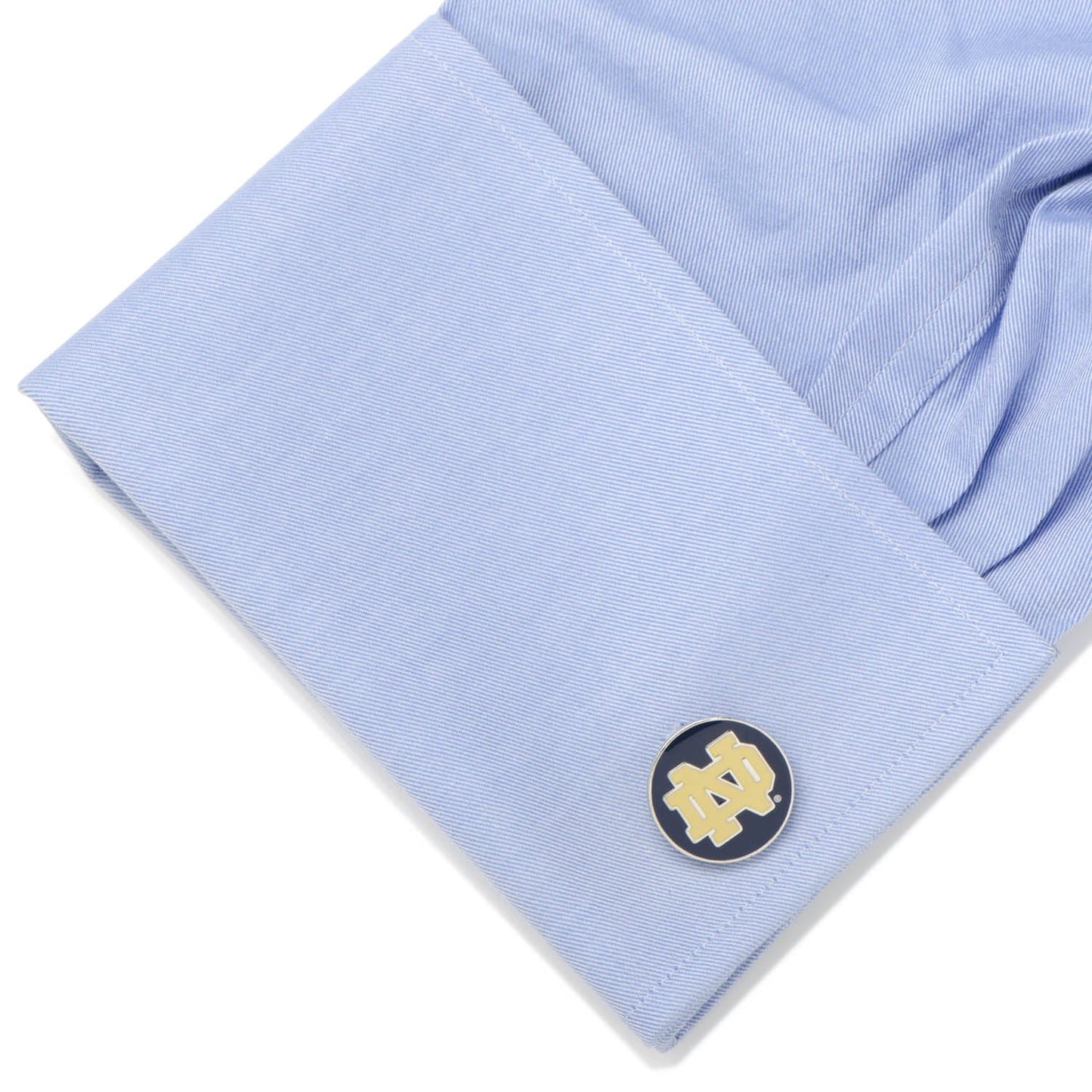 Cufflink on a light blue shirt with a white background