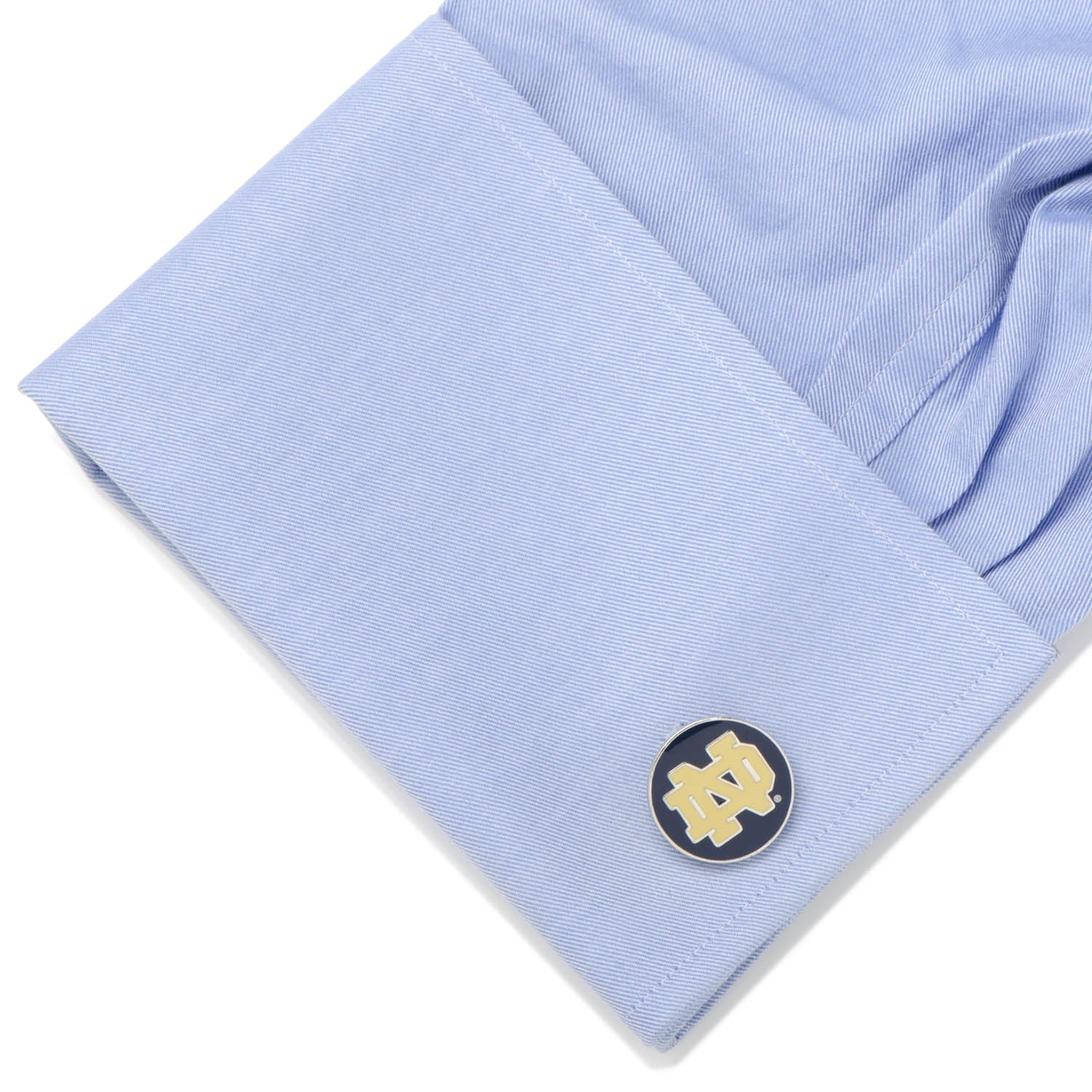Cufflink on a light blue shirt with a white background