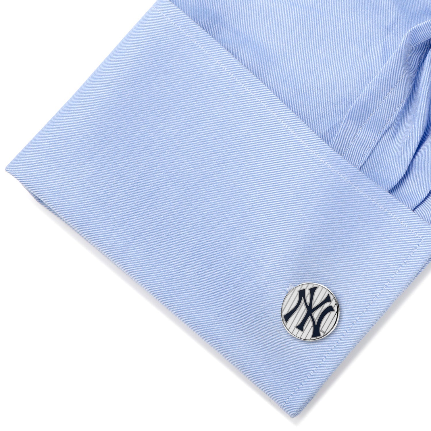 Cufflink with a logo on a light blue shirt sleeve