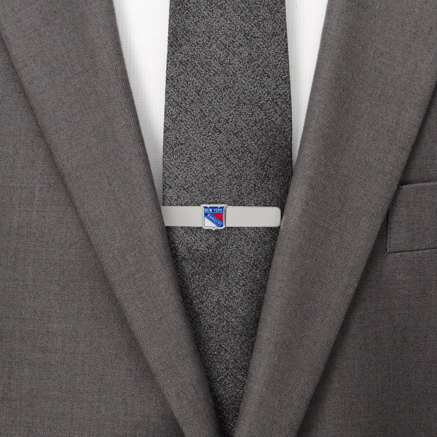 Gray suit jacket with a tie clip on a gray tie