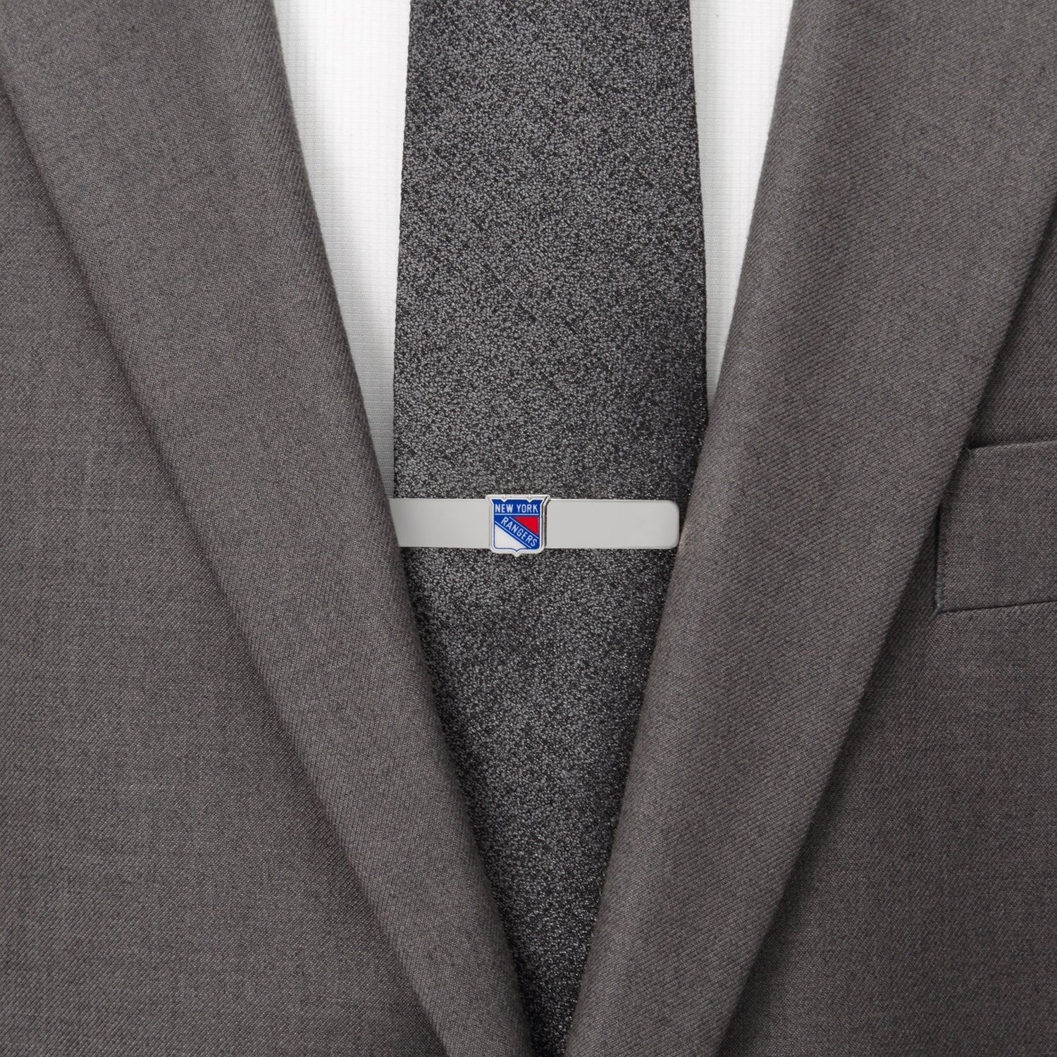 Gray suit jacket with a tie clip on a gray tie