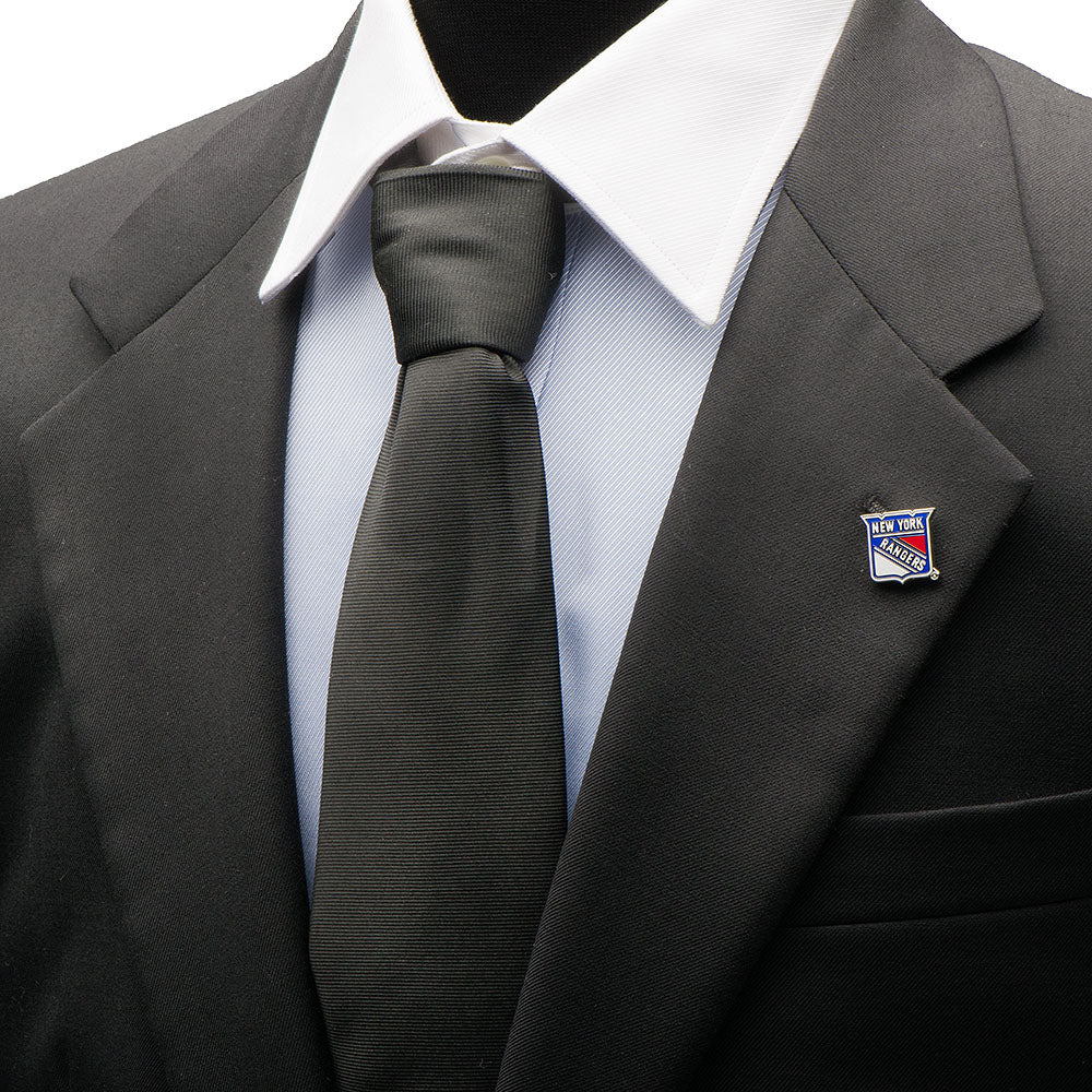 Gray suit with a black tie and New York Rangers lapel pin on a white shirt.