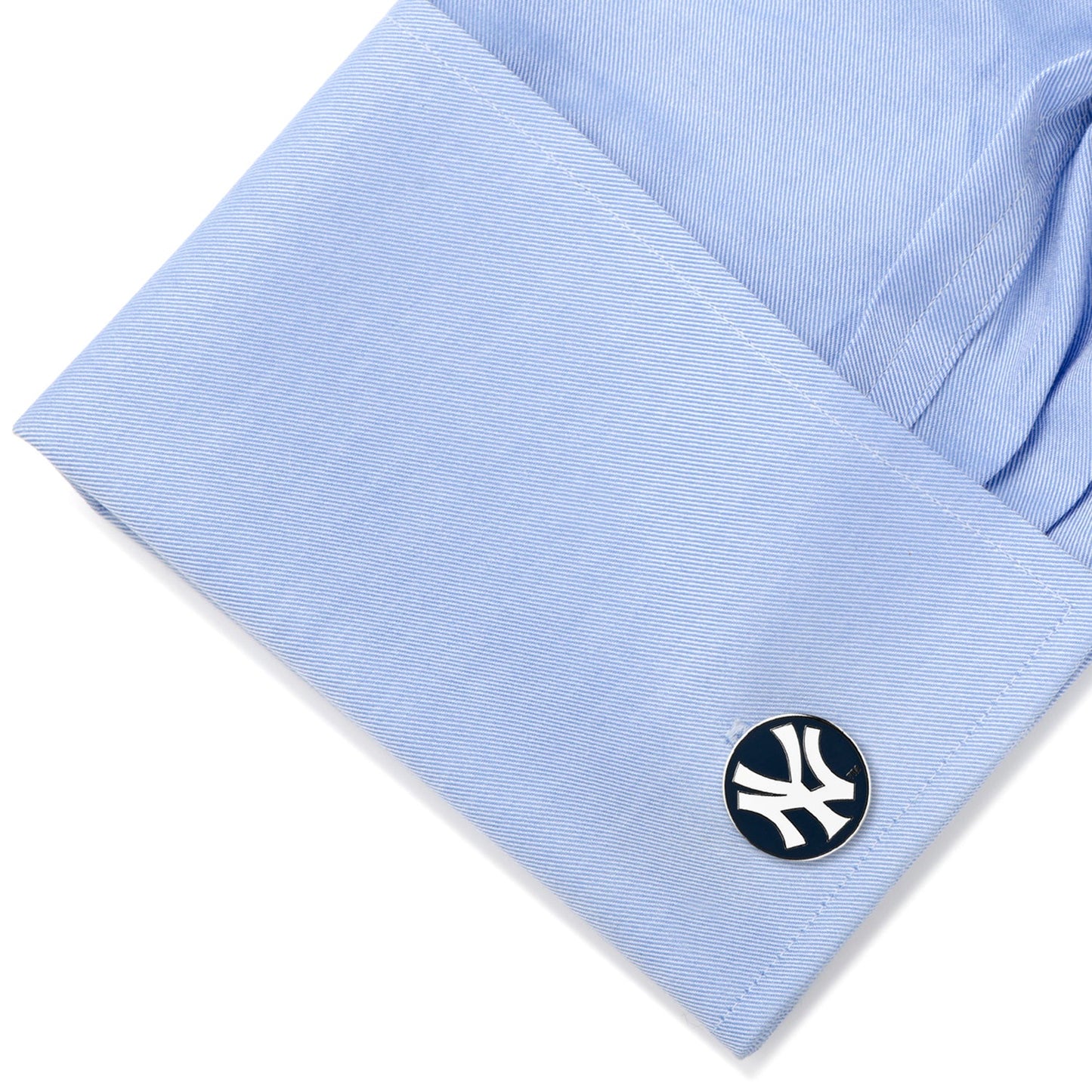 Cufflink on a light blue shirt with a white background