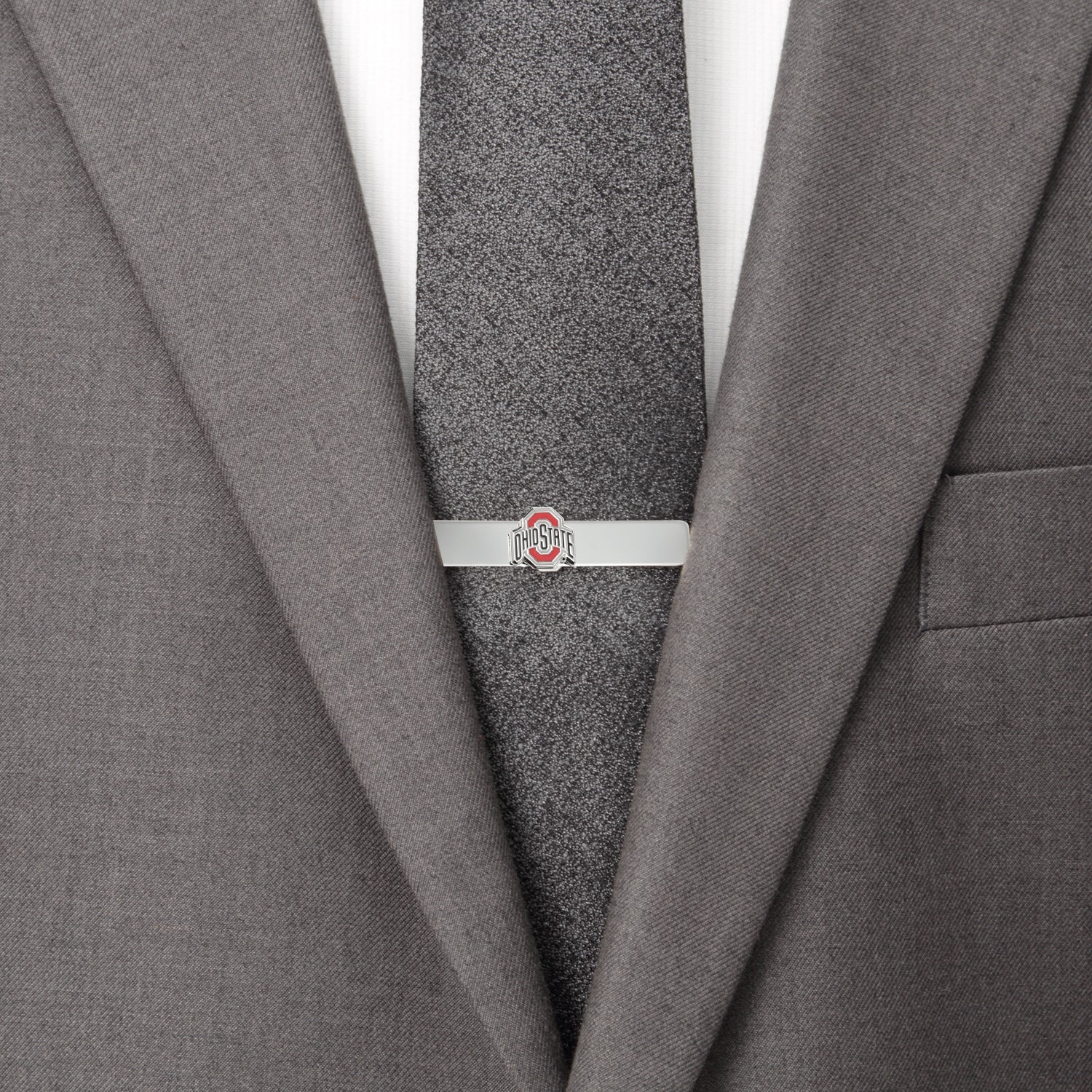 Gray suit jacket with a gray tie and a silver tie clip on a white background