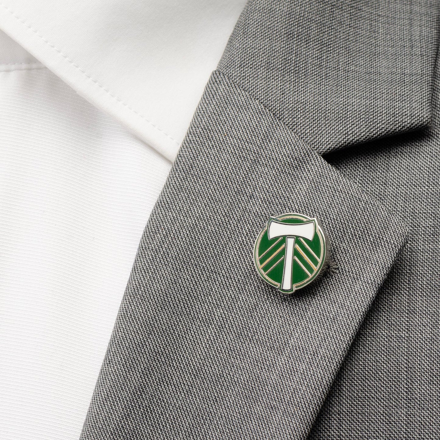 Green and white emblem pin on a gray blazer