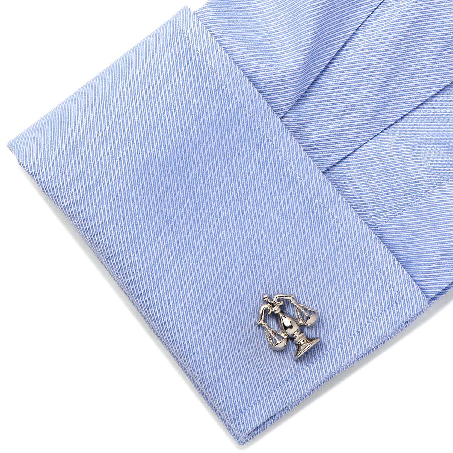 Cufflink on a light blue striped shirt cuff