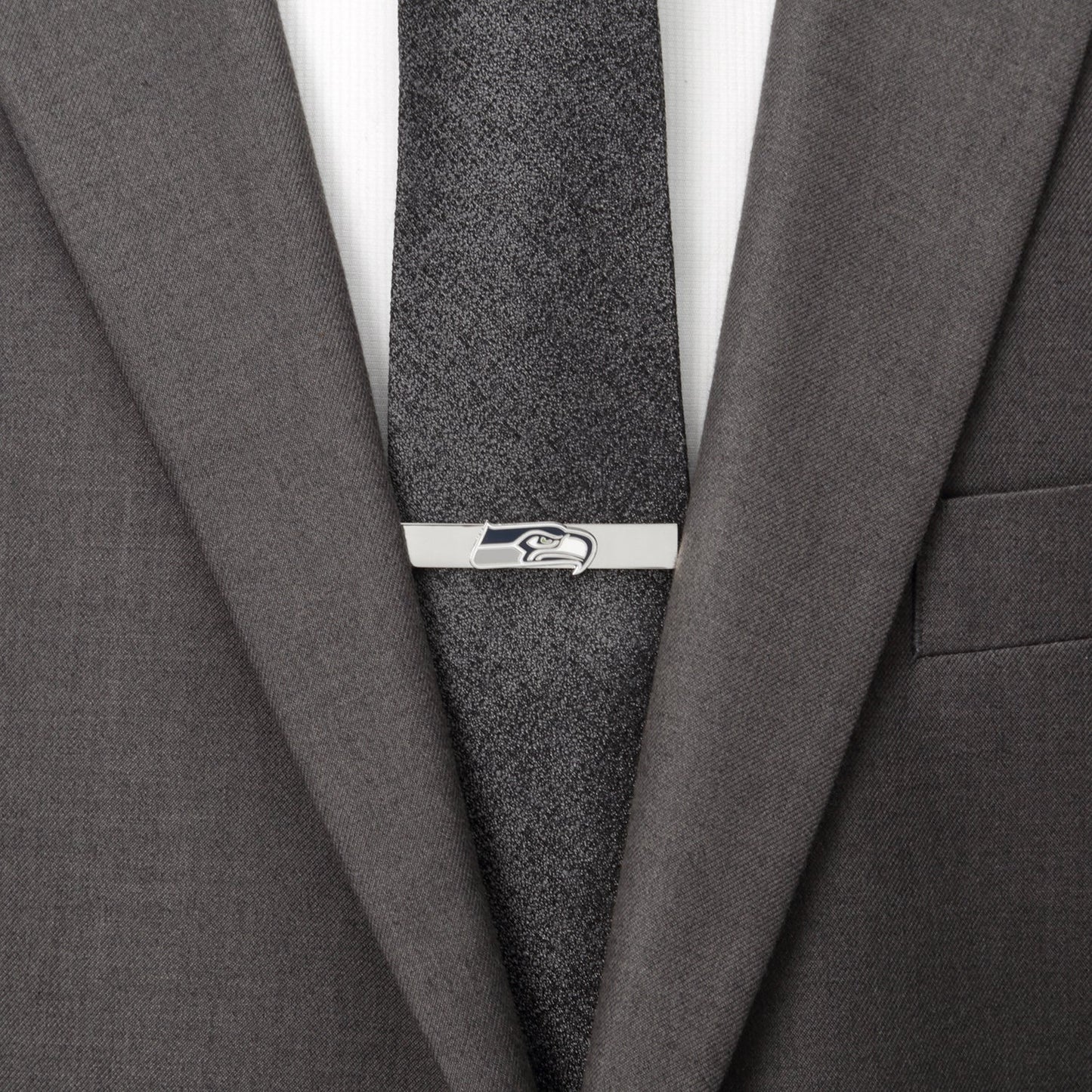 Gray suit jacket with a gray tie and a silver tie clip on a white background