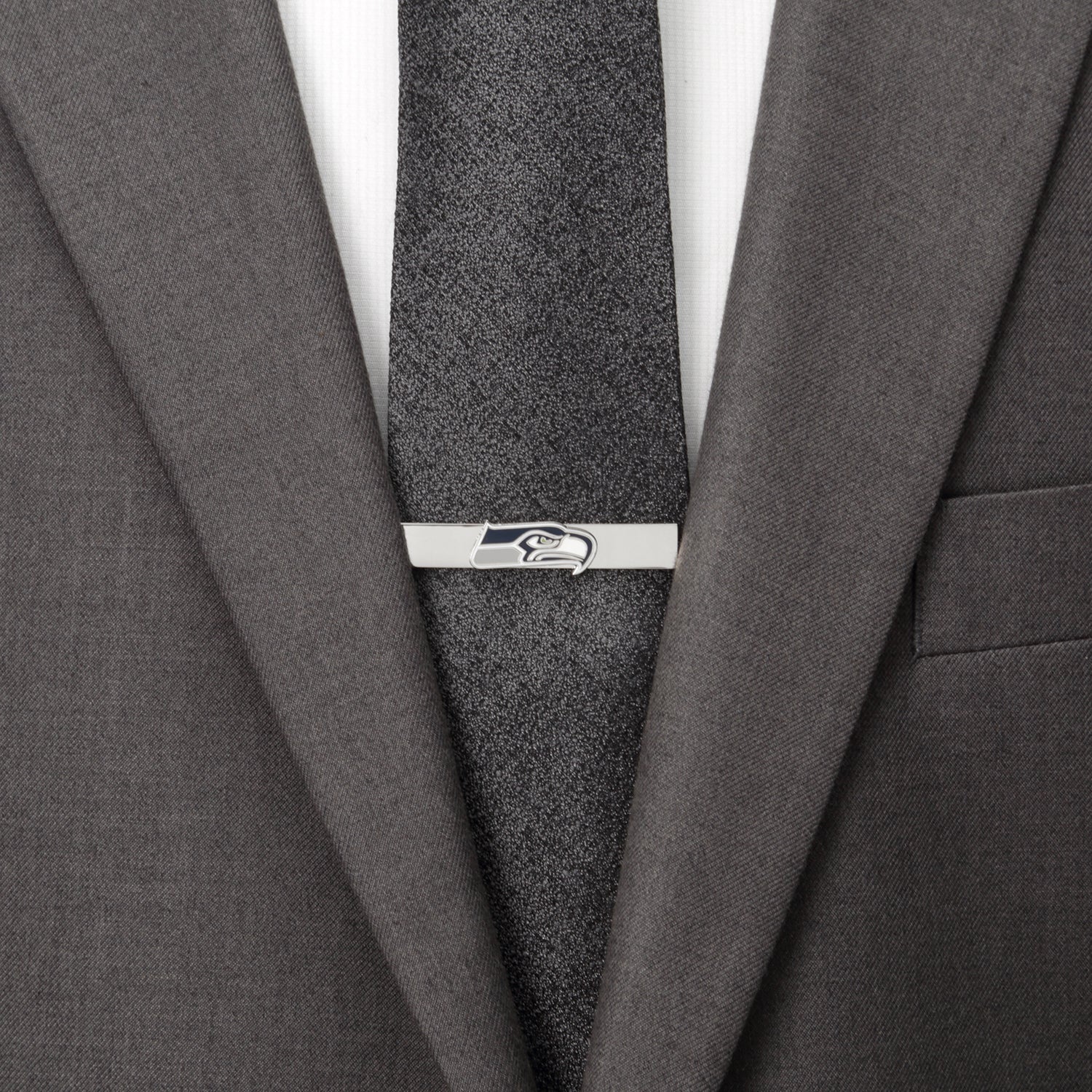 Gray suit jacket with a gray tie and a silver tie clip on a white background