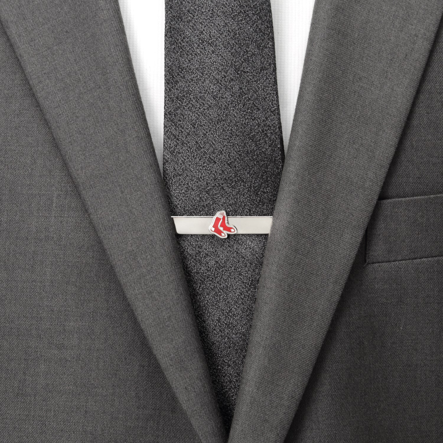 Gray suit with a gray tie and a silver tie clip with red accents.