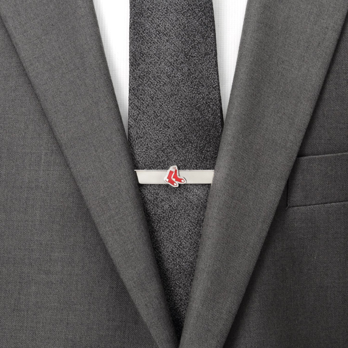 Gray suit with a gray tie and a silver tie clip with red accents.