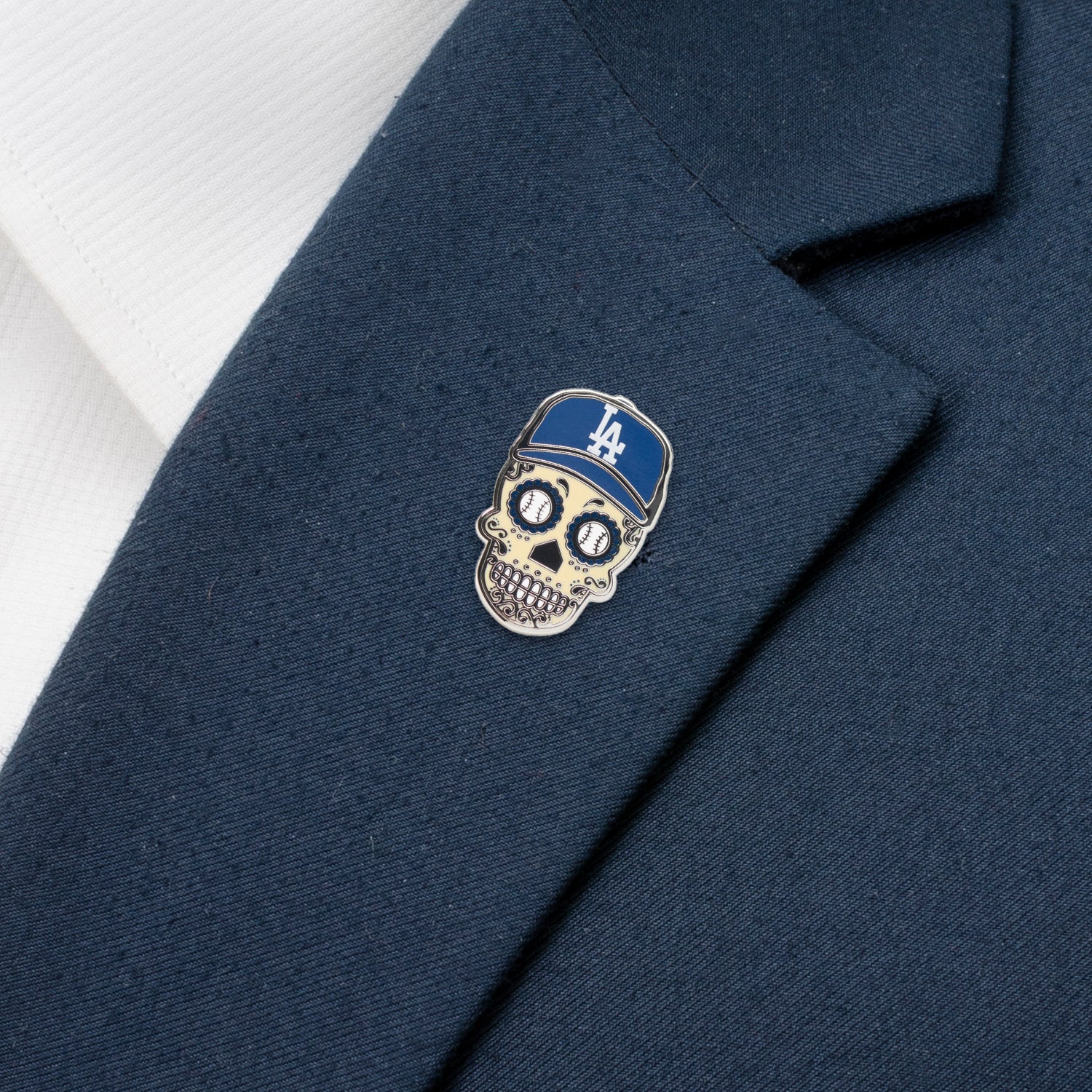 Skull-shaped pin with a blue cap on a navy blazer