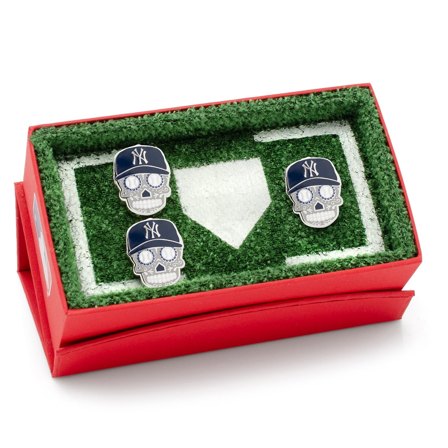 Three skull-shaped cufflinks with New York Yankees hats in a grassy field display case.