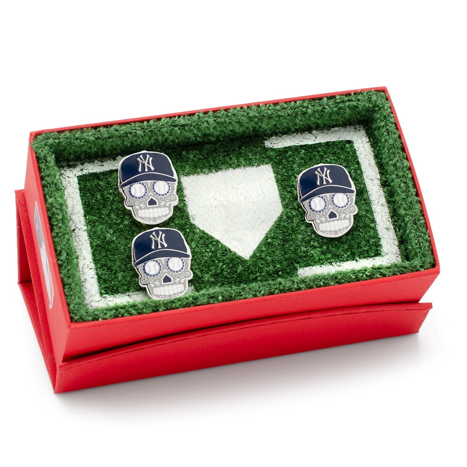 Three skull-shaped cufflinks with New York Yankees hats in a grassy field display case.