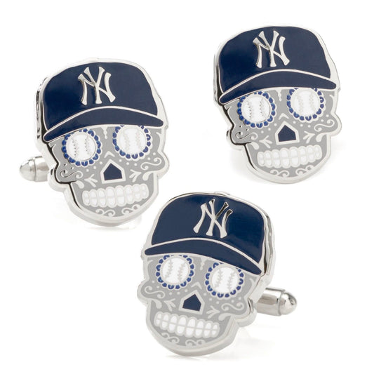 Three skull-shaped cufflinks with New York Yankees caps on a white background