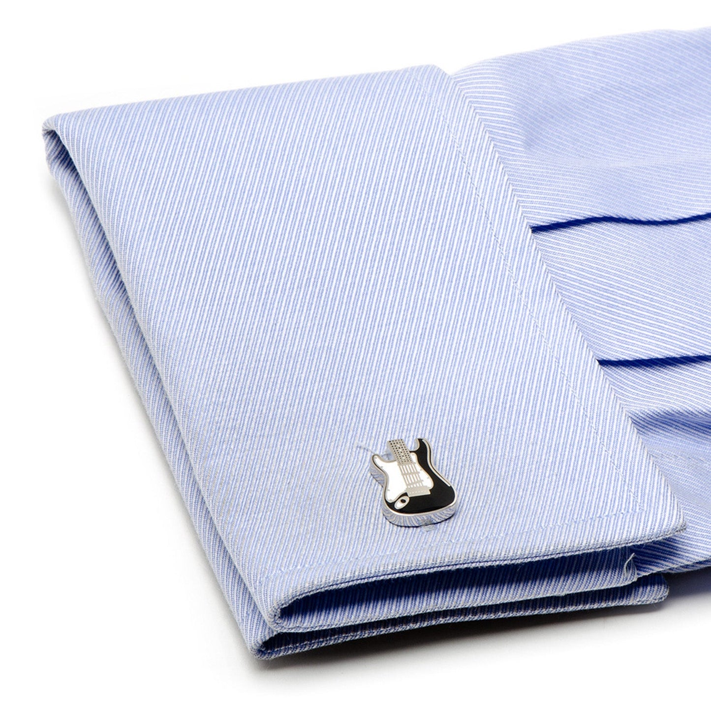 Folded light blue striped shirt with a silver cufflink on a white background