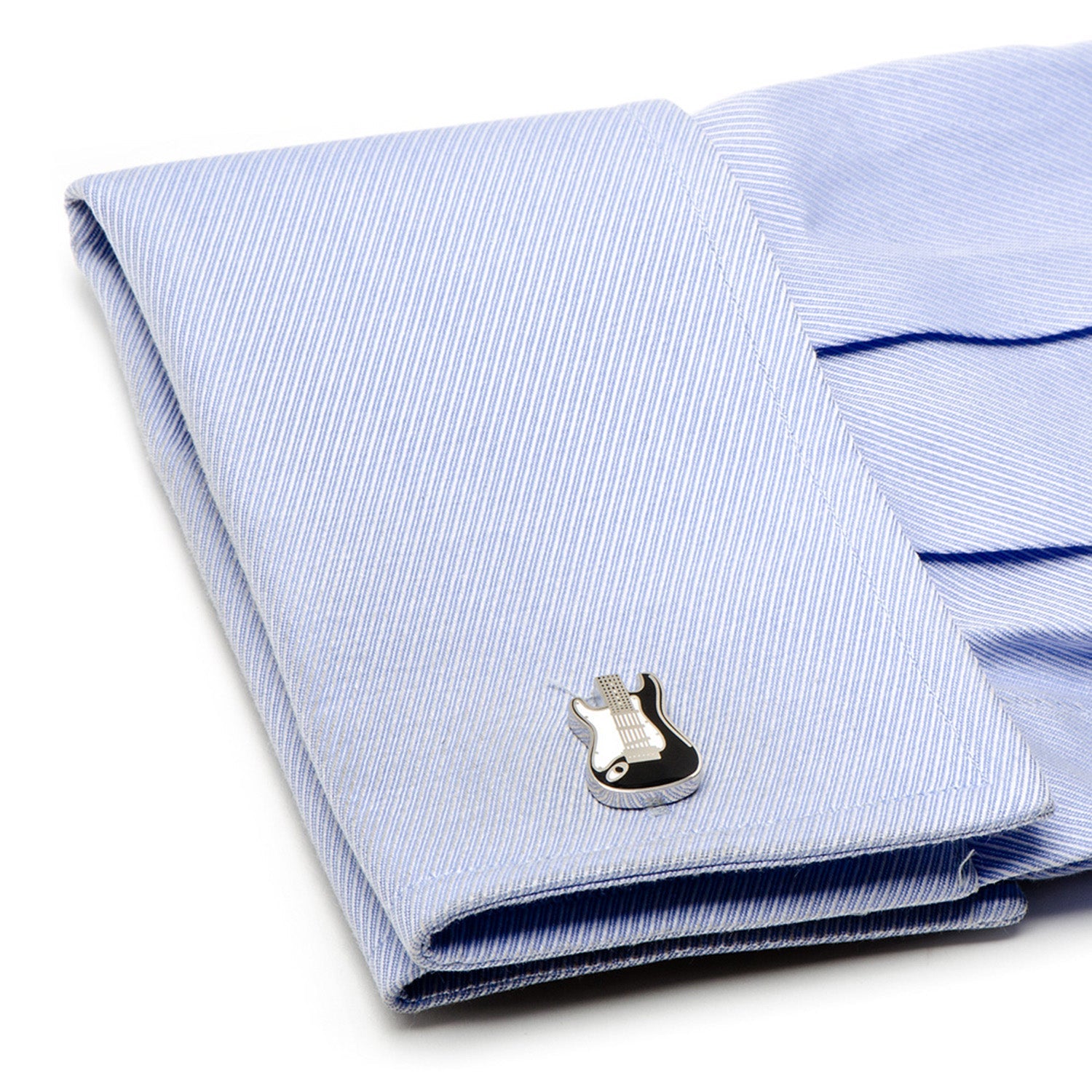 Folded light blue striped shirt with a silver cufflink on a white background