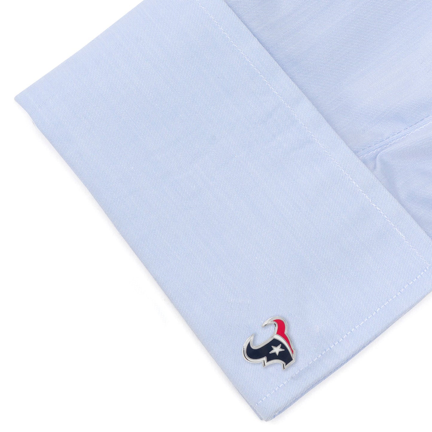 Close-up of a light blue shirt cuff with a small emblem on a white background
