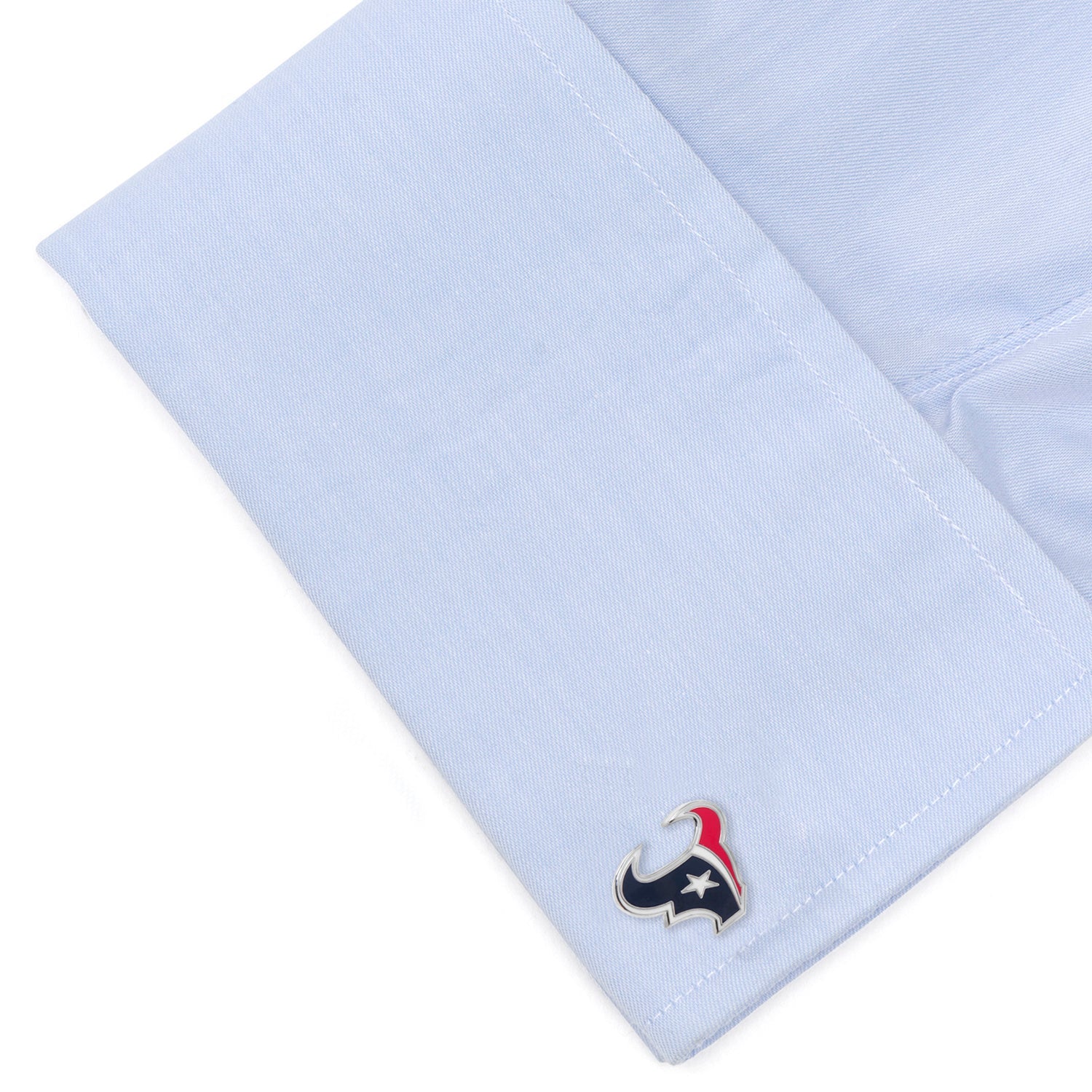Close-up of a light blue shirt cuff with a small emblem on a white background