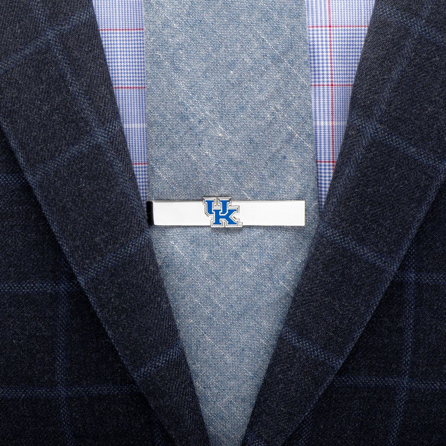 Tie clip with 'UK' logo on a suit jacket and tie