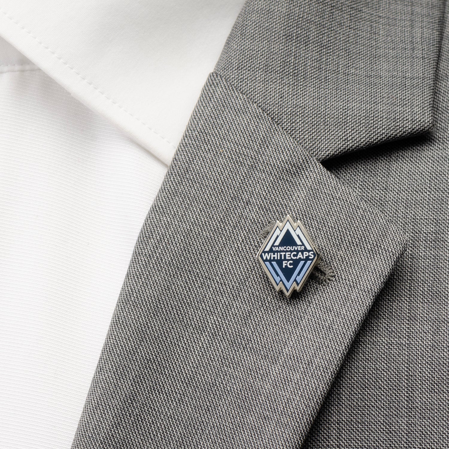 Pin on a gray suit lapel with a white shirt background