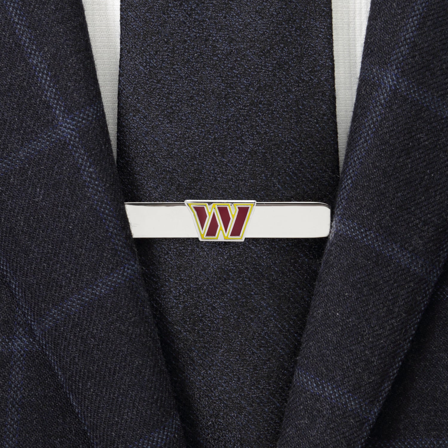 Tie clip with a logo on a suit jacket