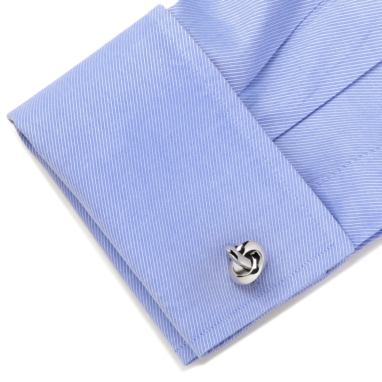 Silver knot cufflink on a light blue dress shirt