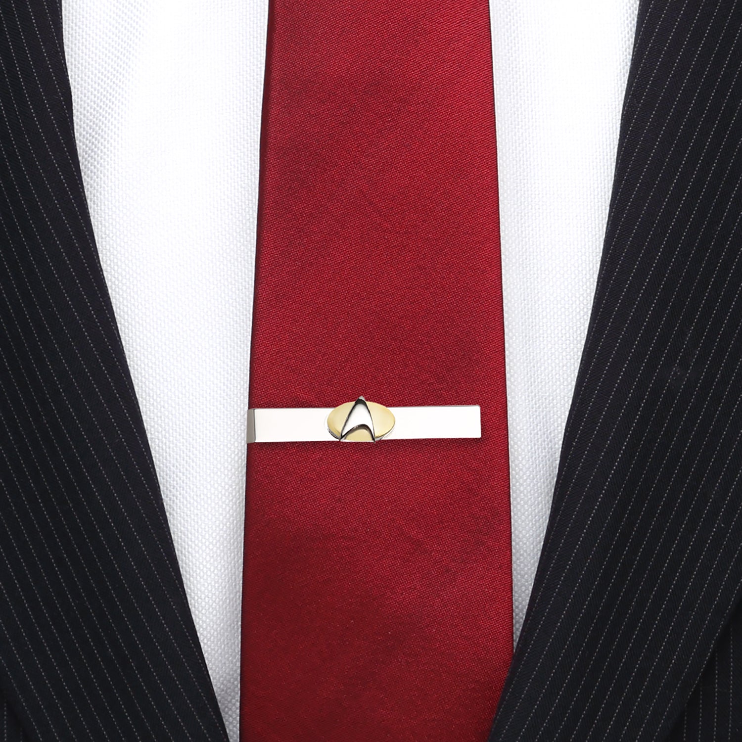 Red tie with a gold tie clip against a white shirt and black pinstripe suit. Star Trek Two Tone Delta Shield Tie Bar