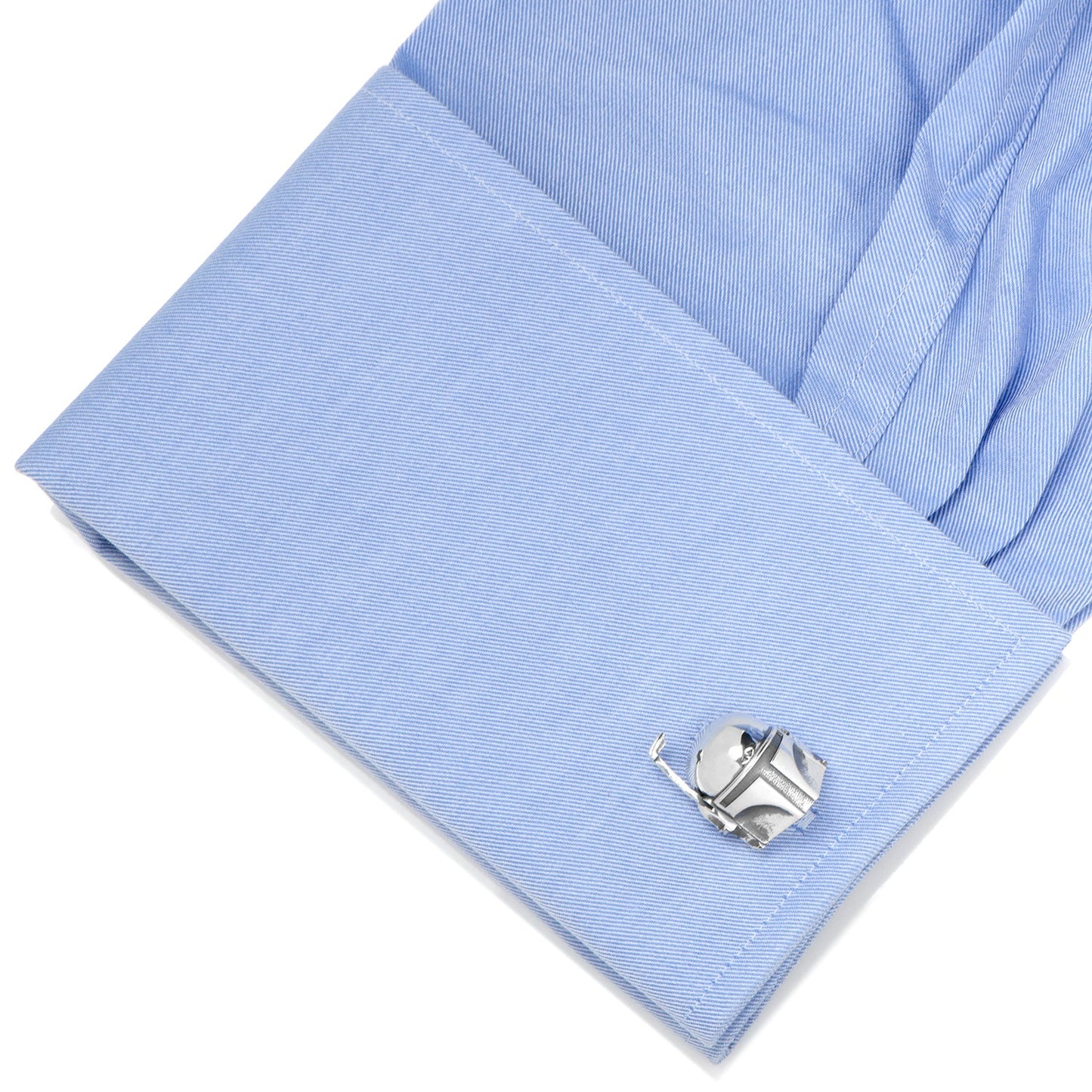Close-up of a light blue shirt cuff with a silver cufflink on a white background