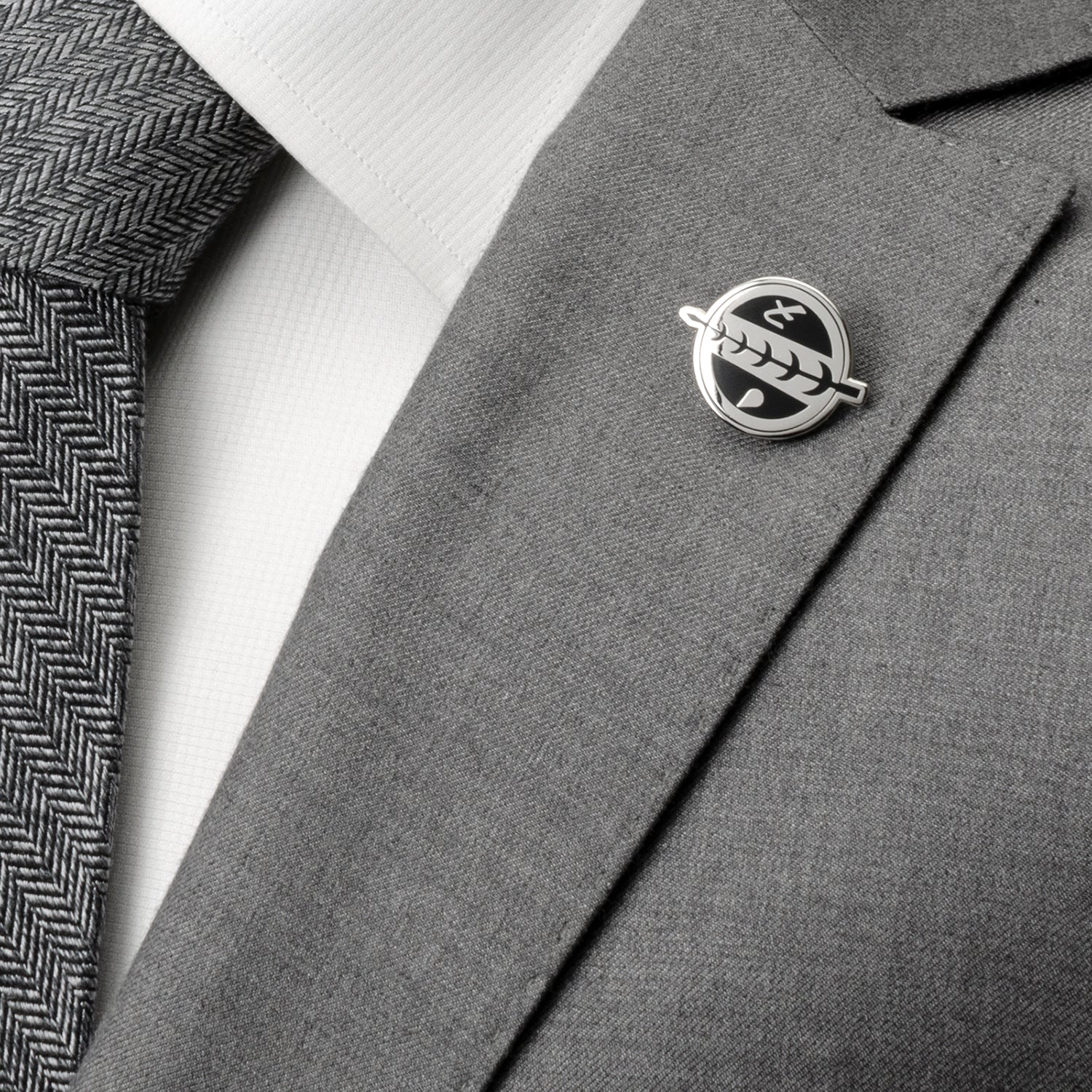 Gray suit jacket with a lapel pin on a white shirt and gray tie.