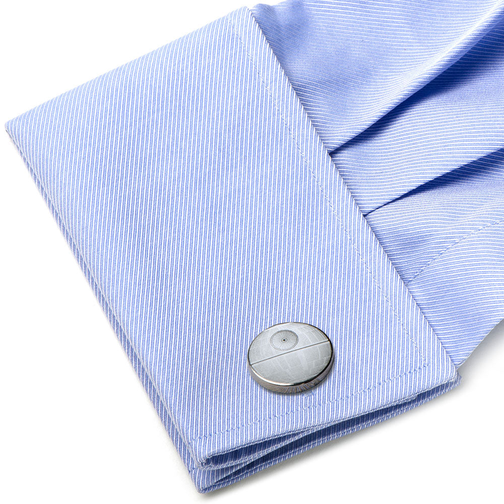 Close-up of a light blue striped shirt with a cufflink on a white background