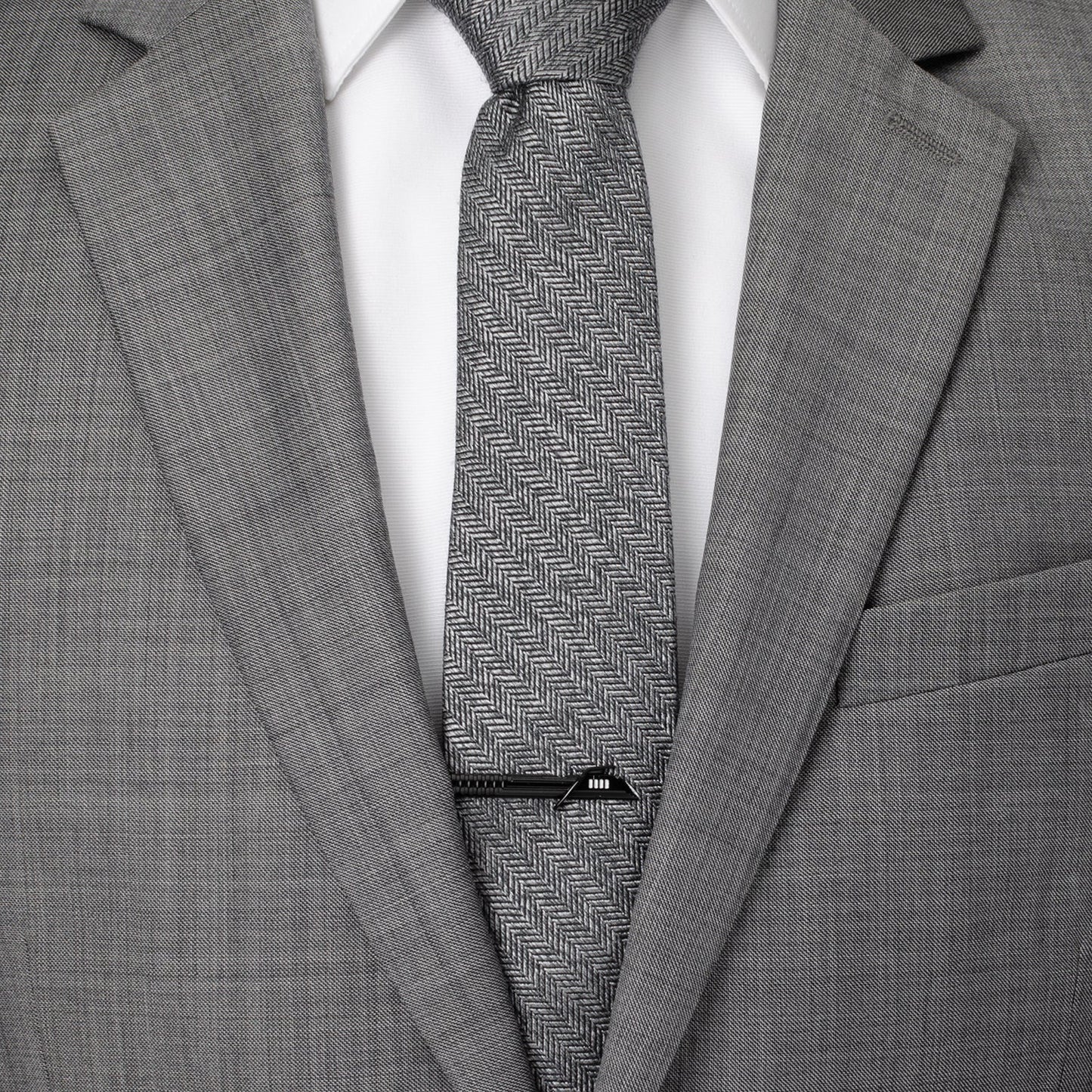 Gray suit with a patterned tie and visible brand label.