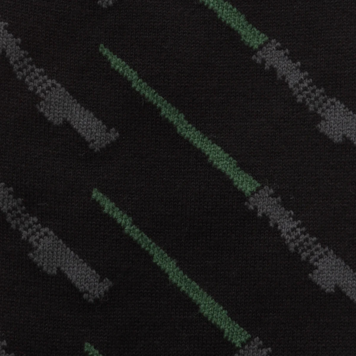 Close-up of a patterned fabric with green and gray lines on a black background