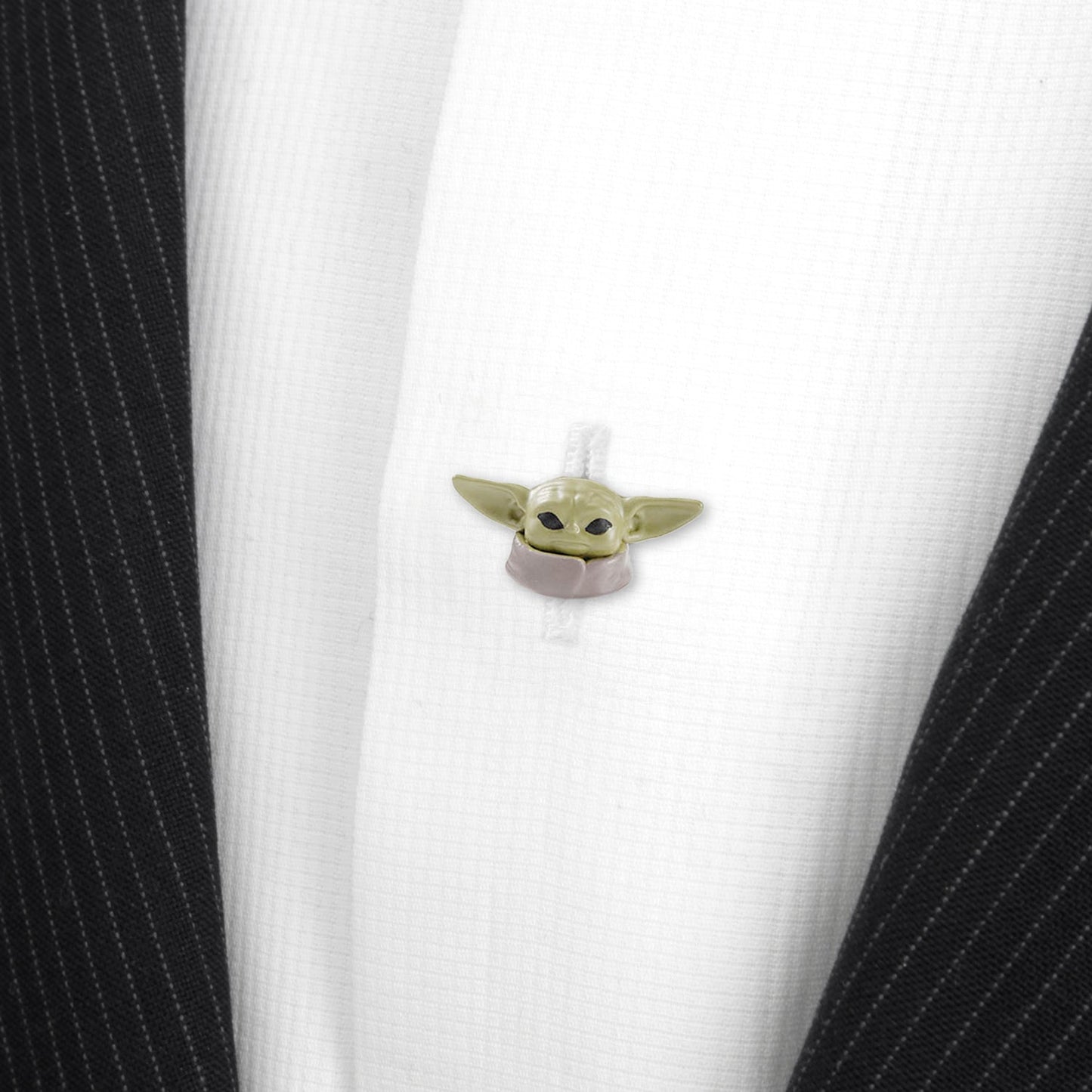 Small green character attached to a white shirt with black pinstripes