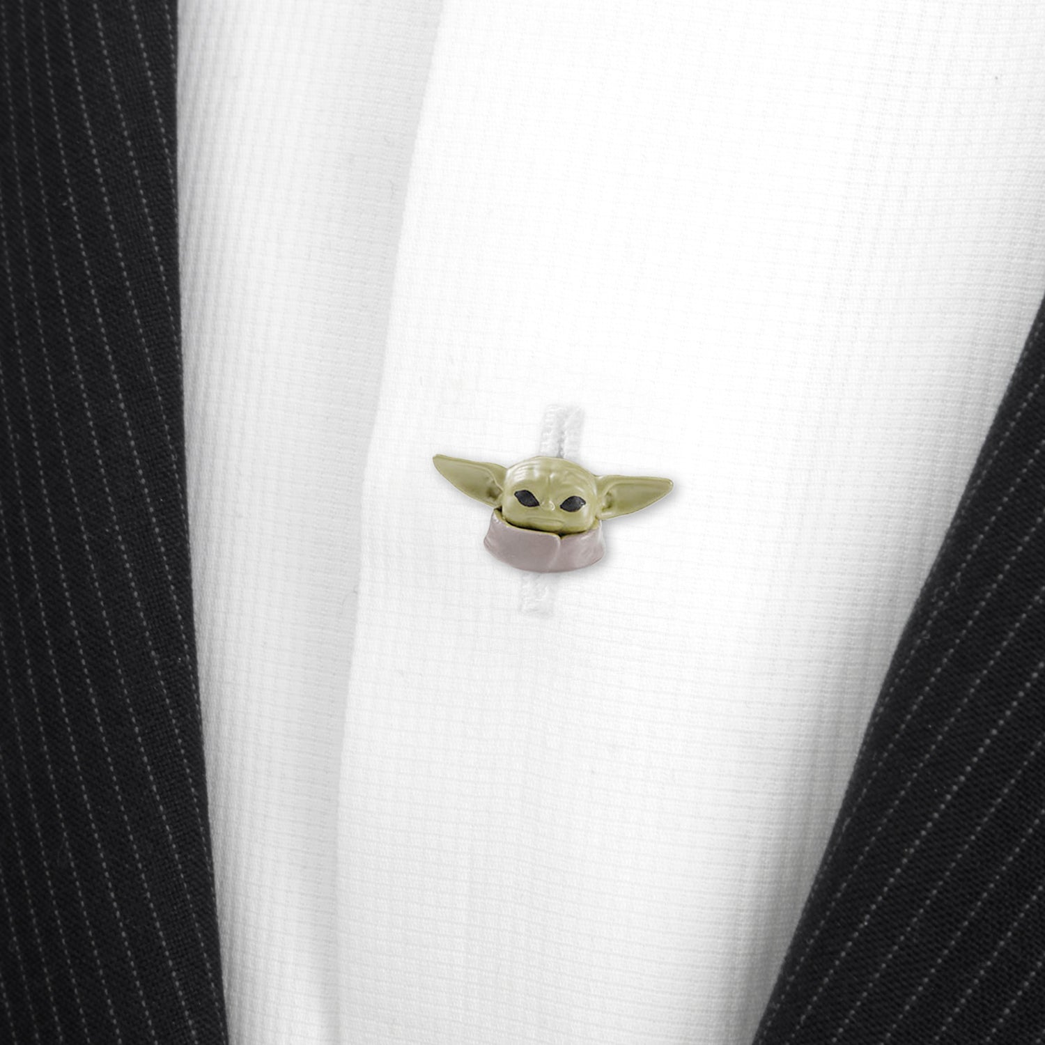 Small green character attached to a white shirt with black pinstripes