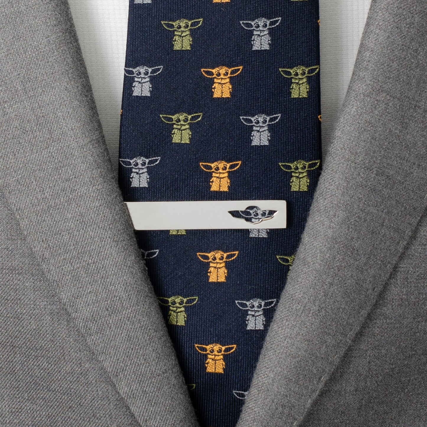 Navy tie with character pattern worn with a gray suit jacket