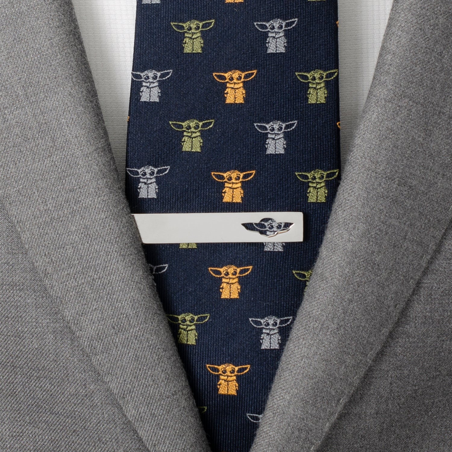Navy tie with character pattern worn with a gray suit jacket