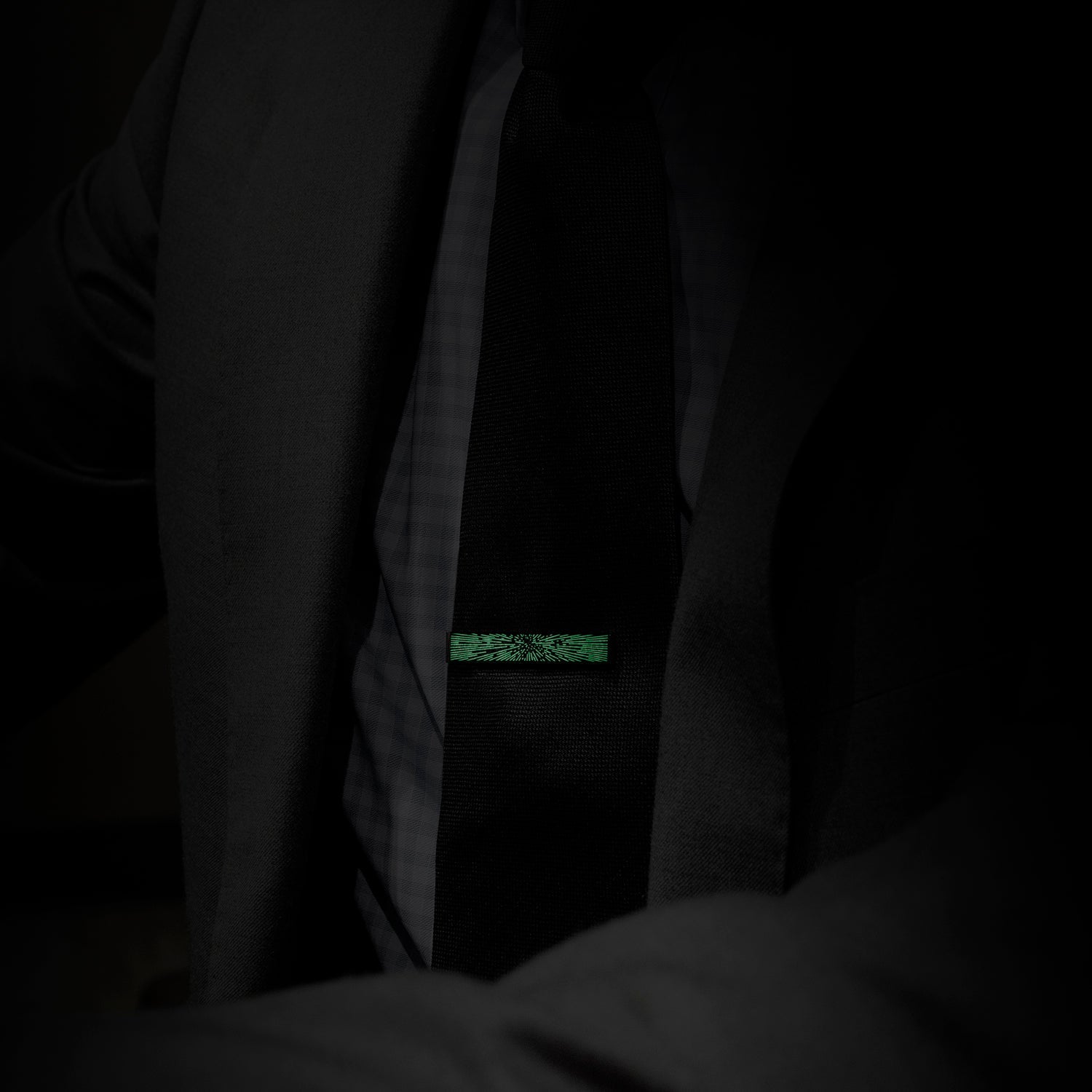 Dark coat with a green label on a black background