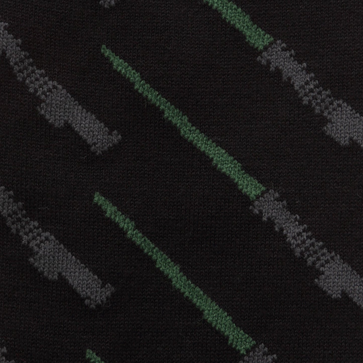 Close-up of a patterned fabric with green and gray lines on a black background