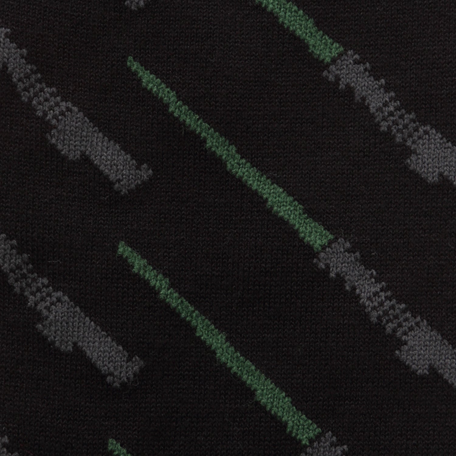 Close-up of a patterned fabric with green and gray lines on a black background