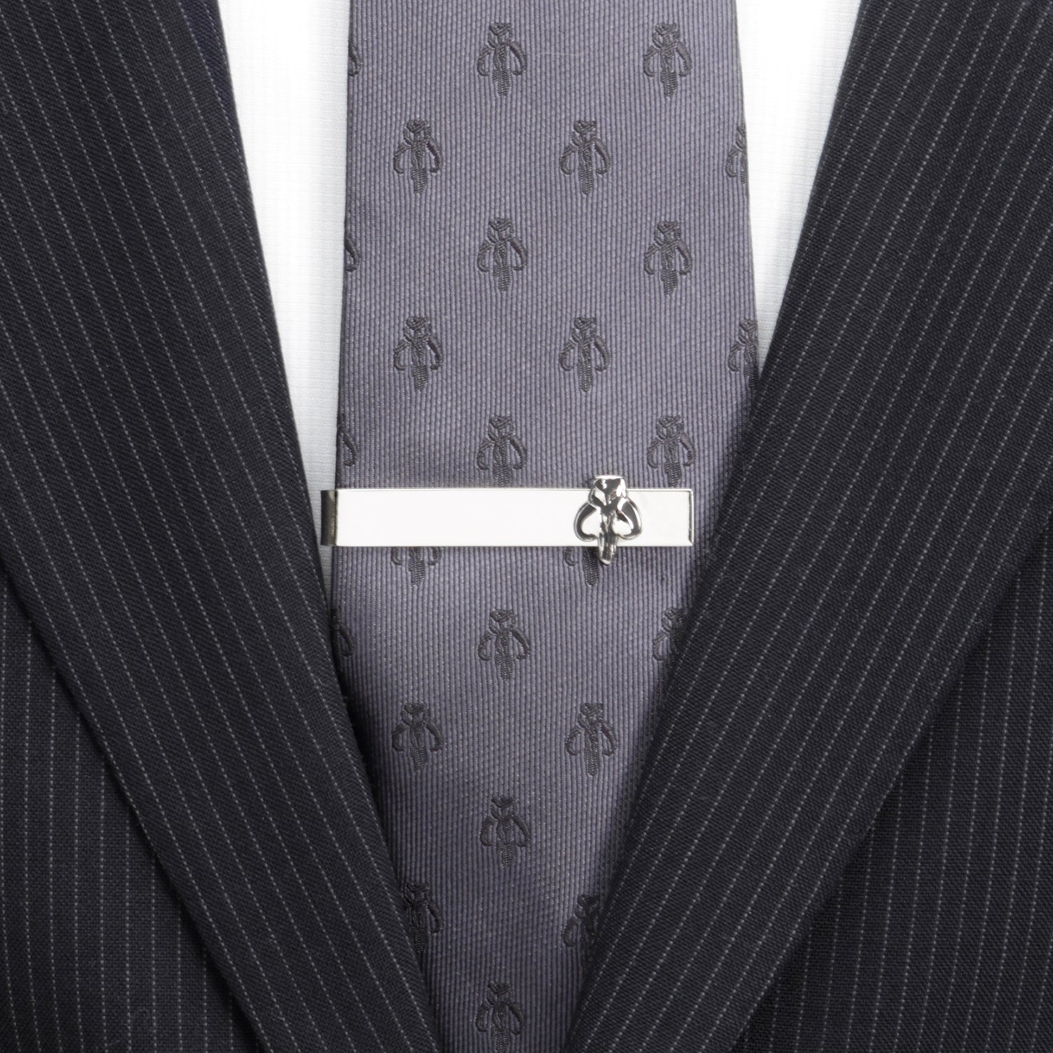 Gray patterned tie with a silver tie clip on a suit jacket