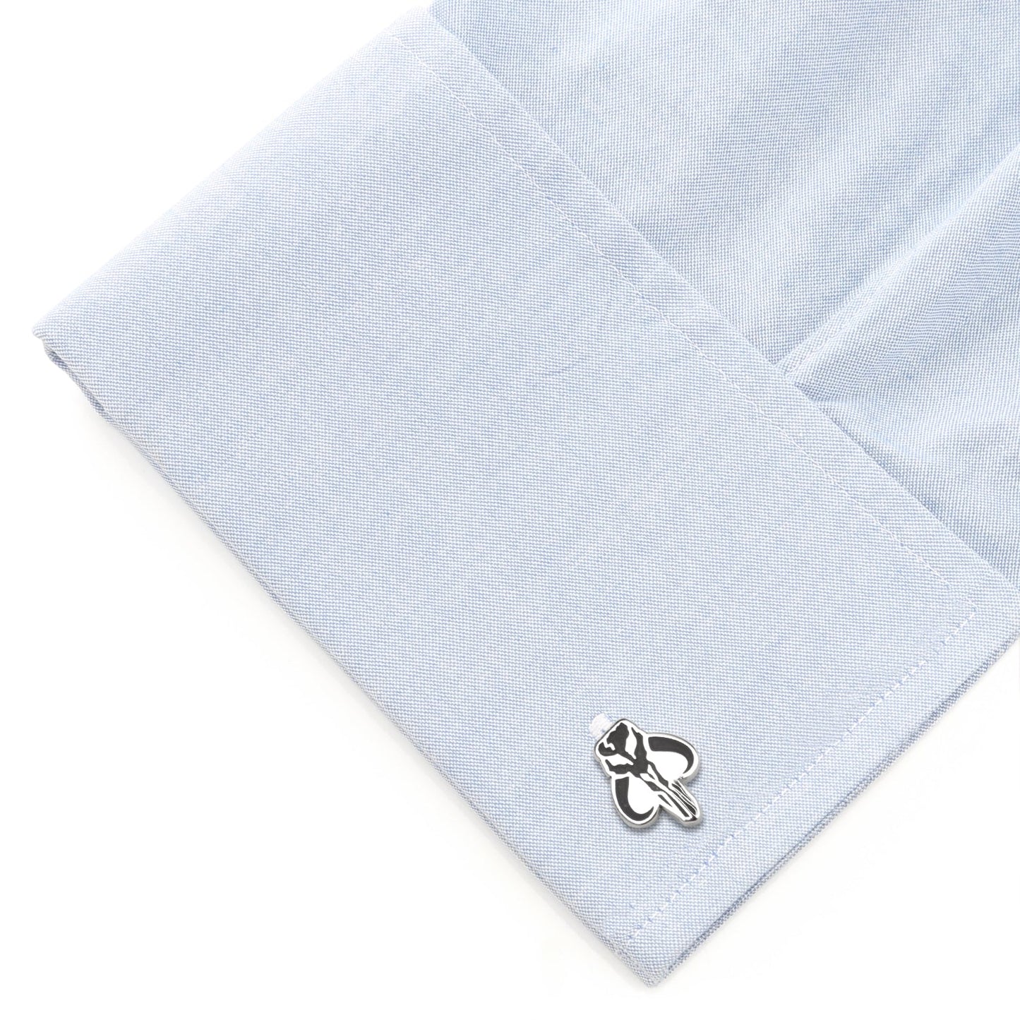 Cufflink on a light blue textured fabric background