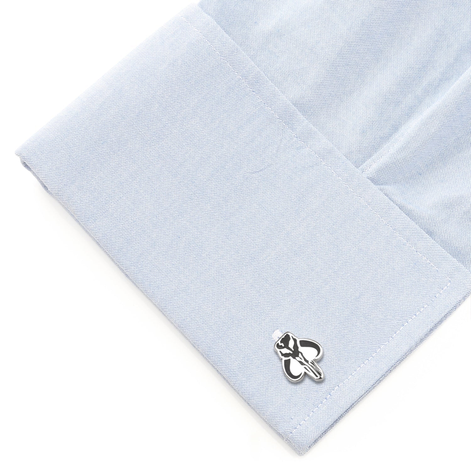 Cufflink on a light blue textured fabric background