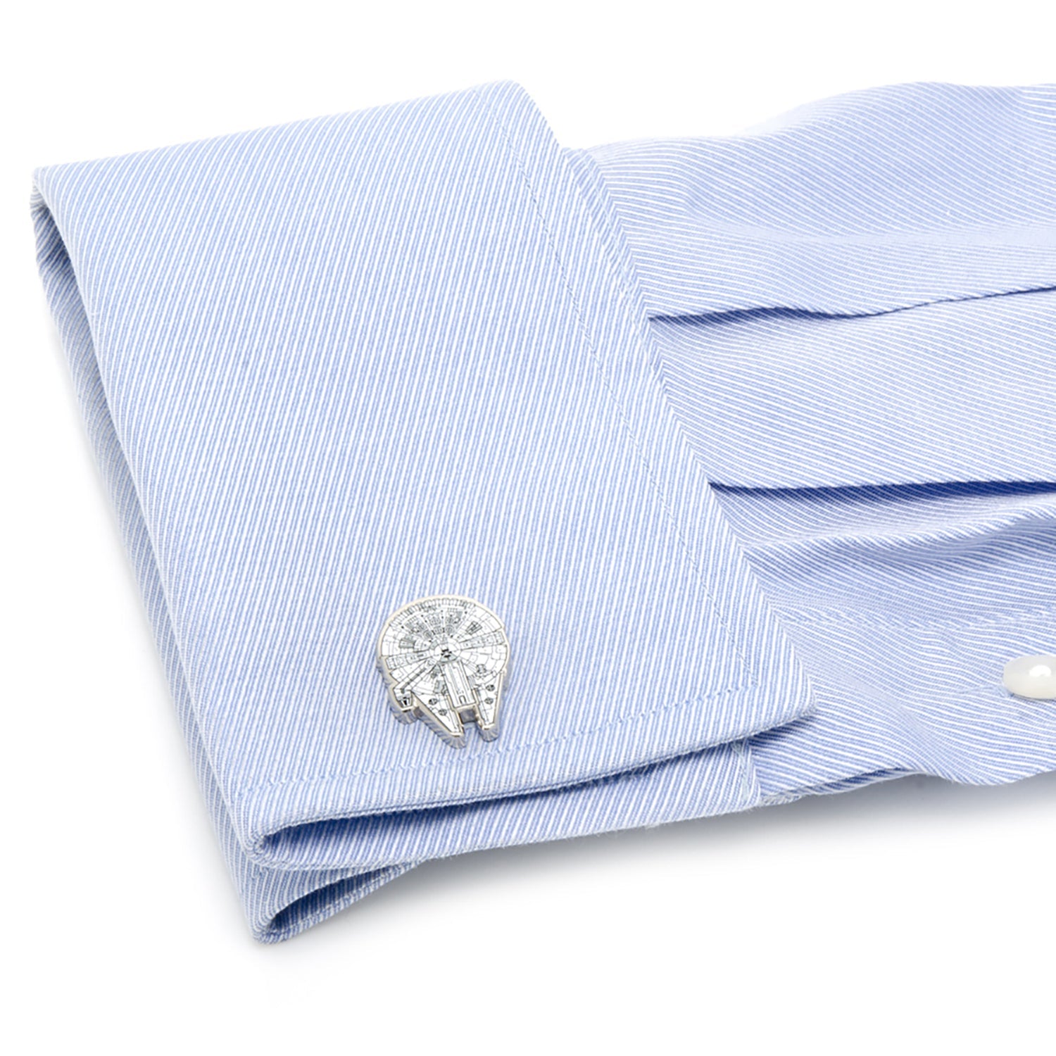 Cufflinks on a light blue dress shirt with a white background