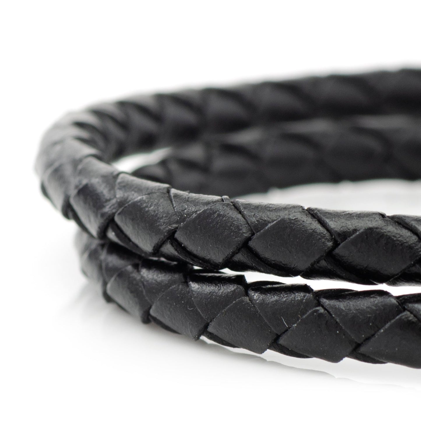 Close-up of a braided black leather bracelet on a white background