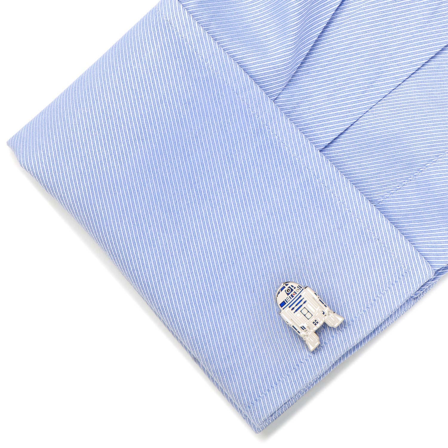 Cufflink shaped like a robot on a light blue striped shirt cuff