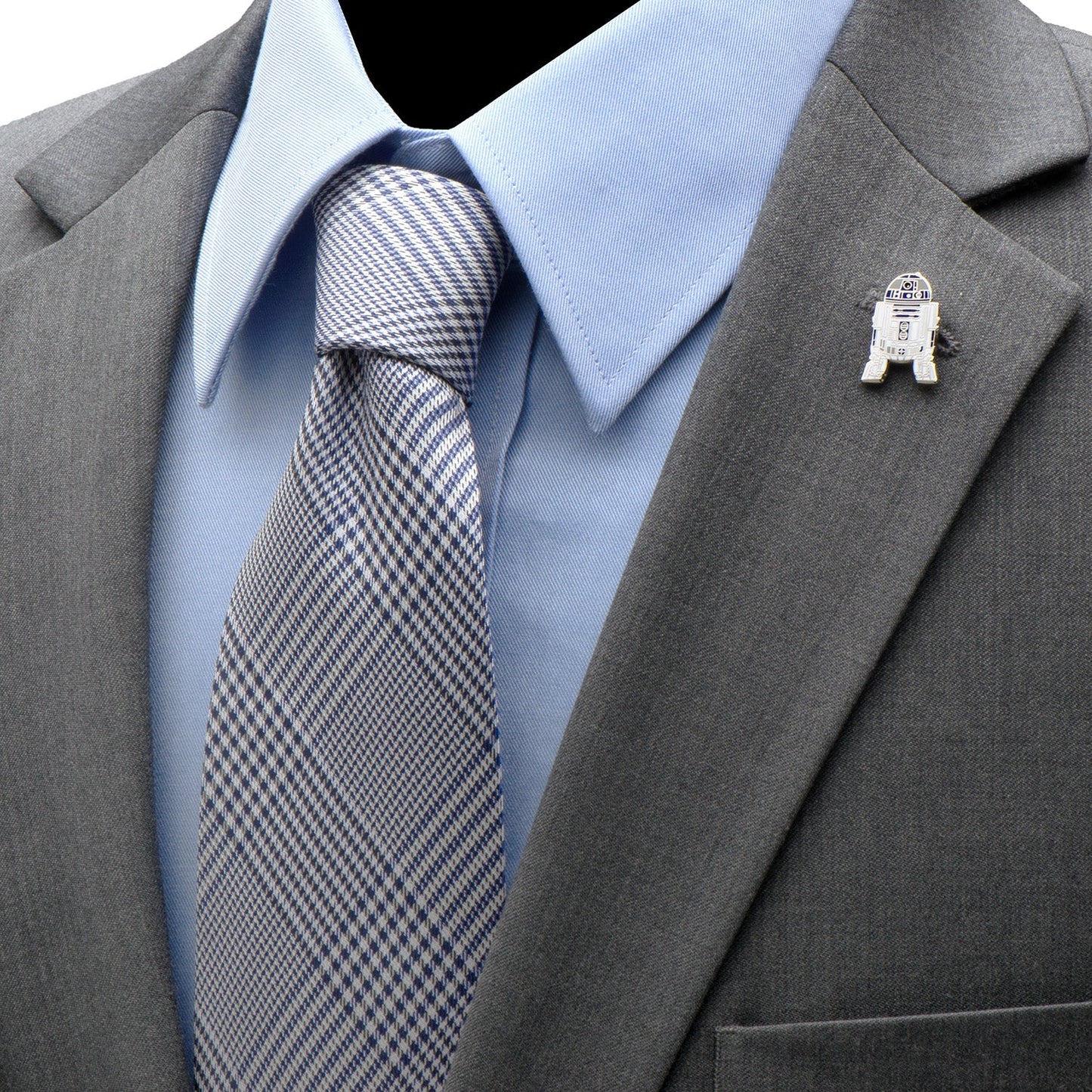 Gray suit with blue shirt, patterned tie, and R2D2 pin on gray jacket.