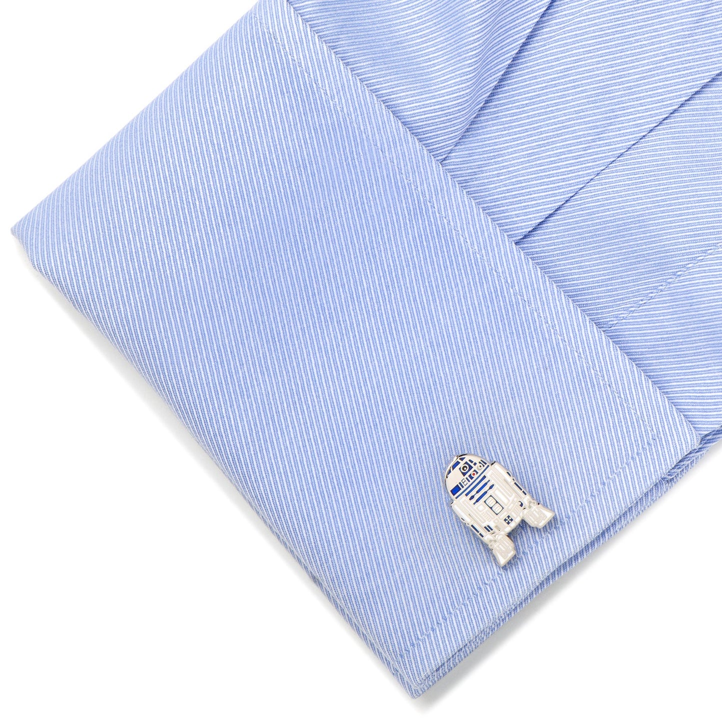 Cufflink shaped like R2-D2 from Star Wars on a light blue striped shirt.